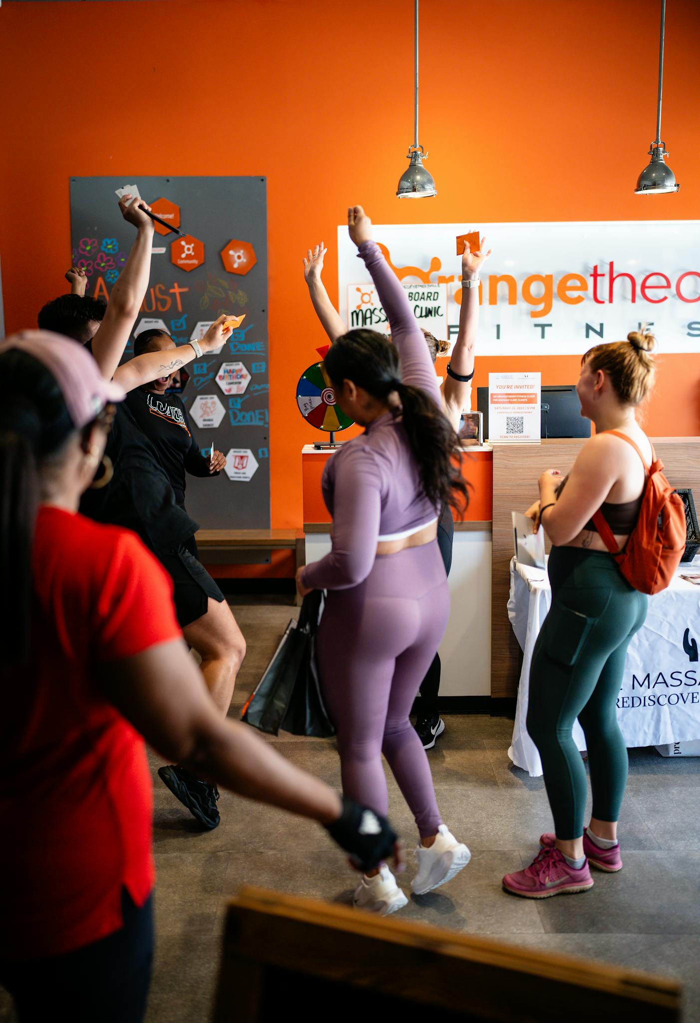 Women in activewear celebrating after a workout in an indoor fitness studio.
